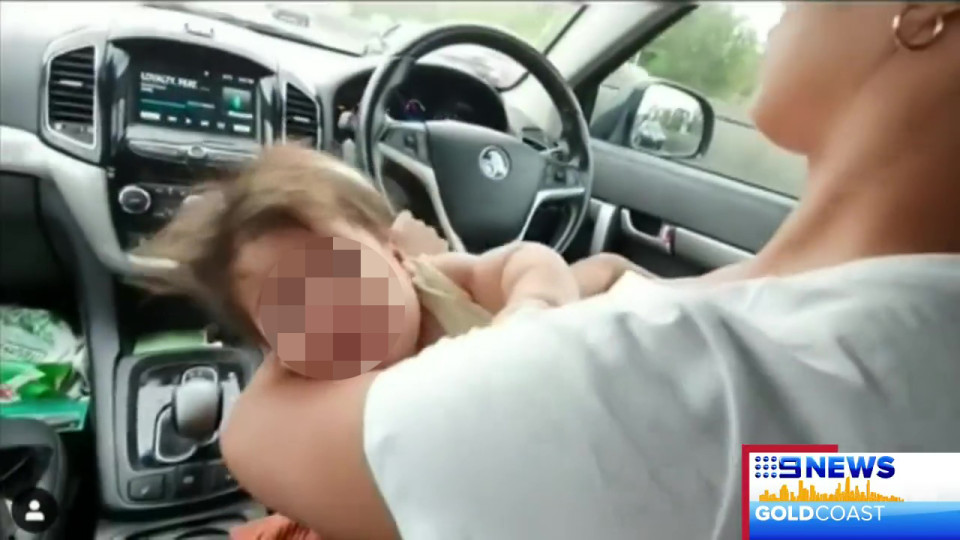 سيدة ترضع طفلها خلال القيادة على الطريق السريع