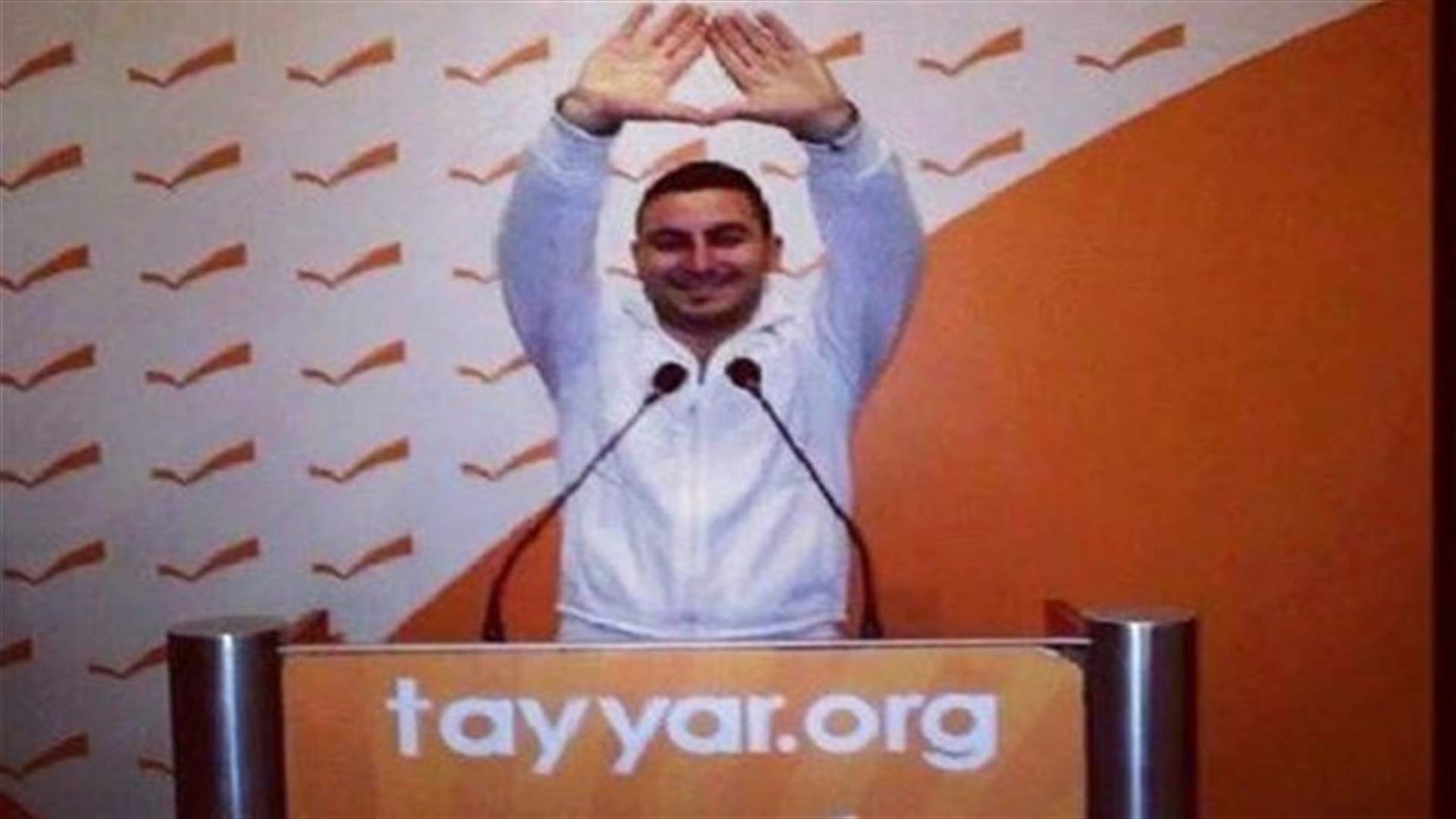 Citizen rises LF hand signal on MP Michel Aoun's rostrum in Rabieh