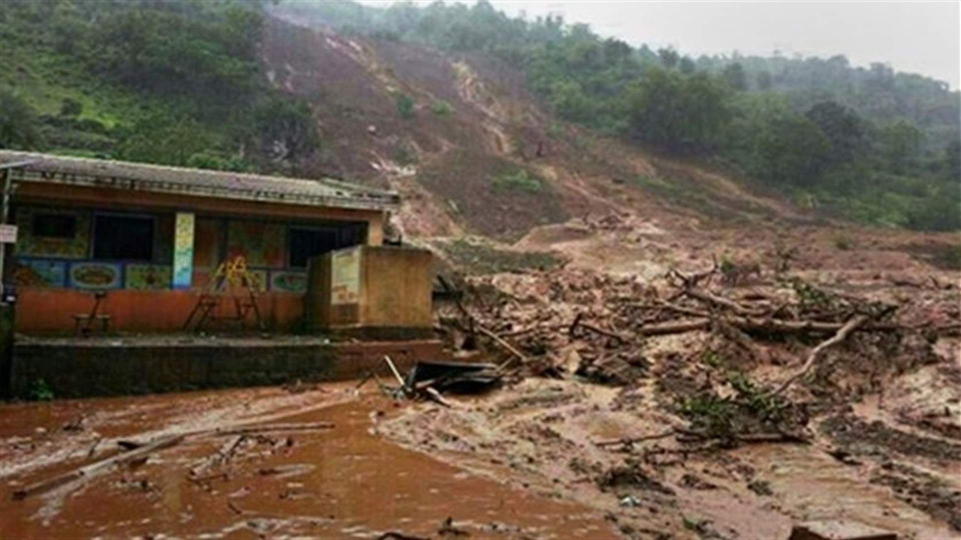 Rescuers slog through waist-deep mud to dig out submerged village houses after landslide
