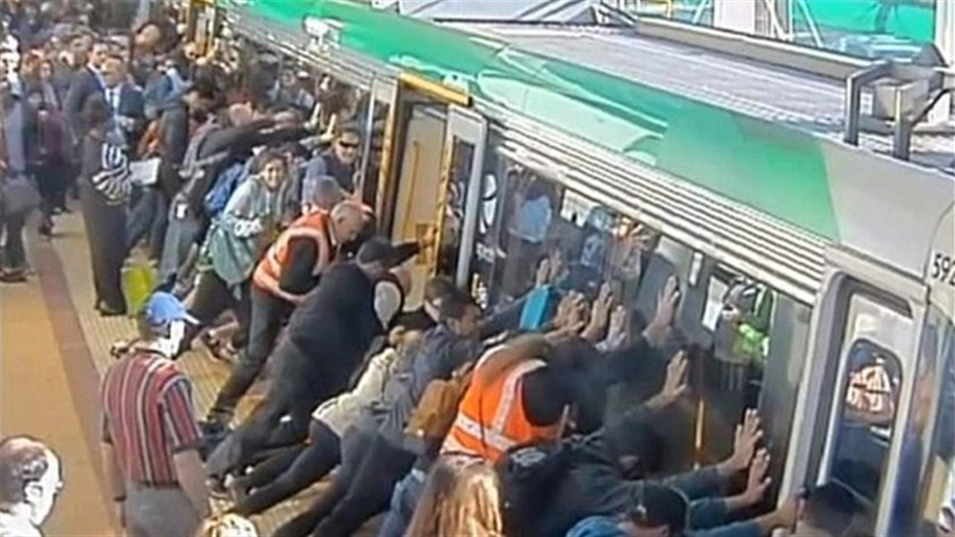 People push train together, rescue trapped man