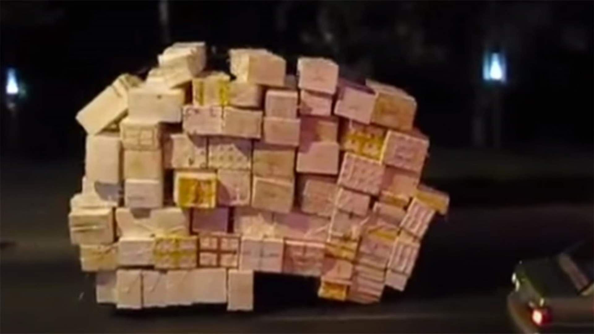 [VIDEO] Someone Is Riding A Tricycle Under A Moving Stack Of Crates
