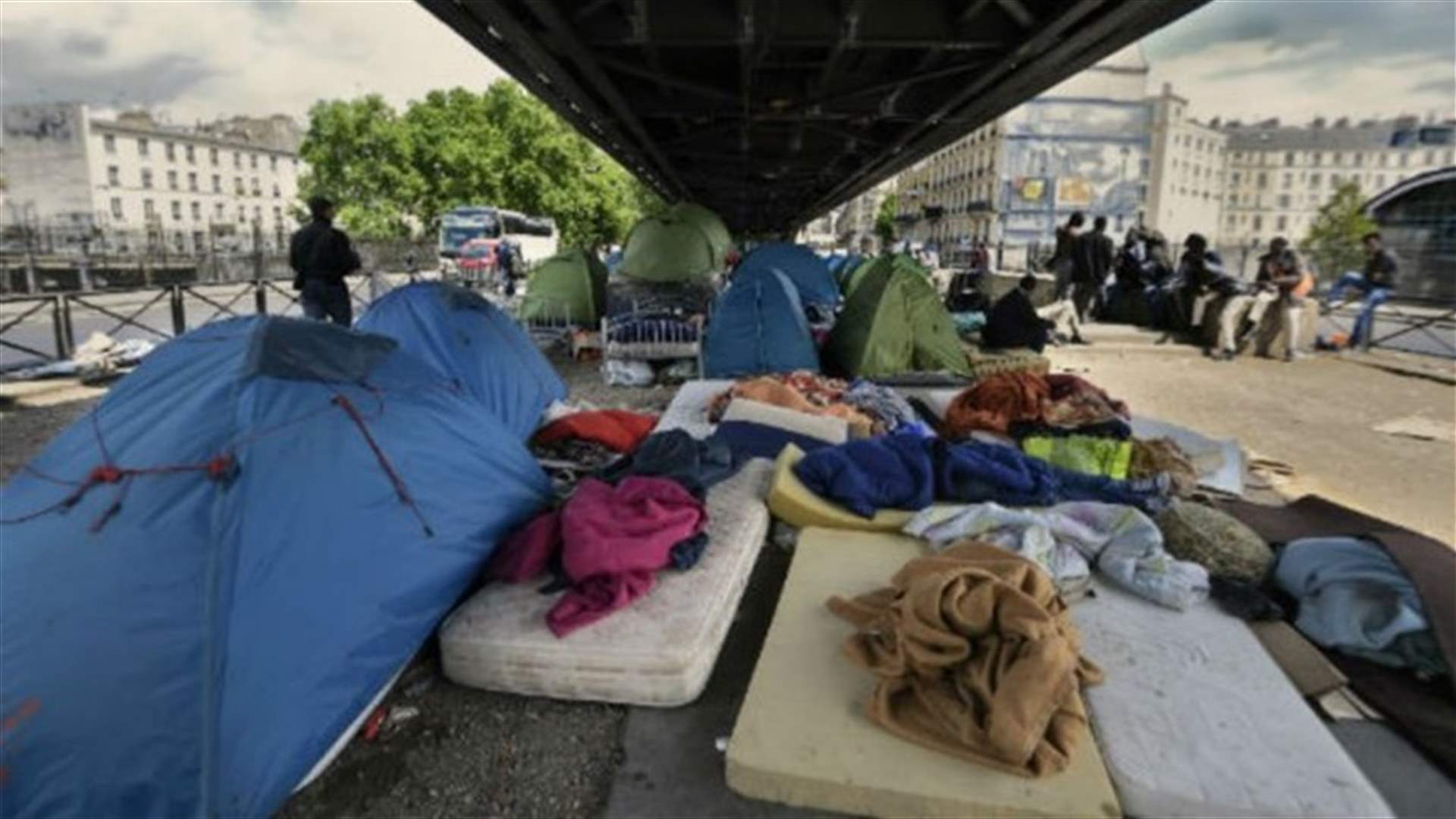 Police evacuate migrant families from Paris sidewalks