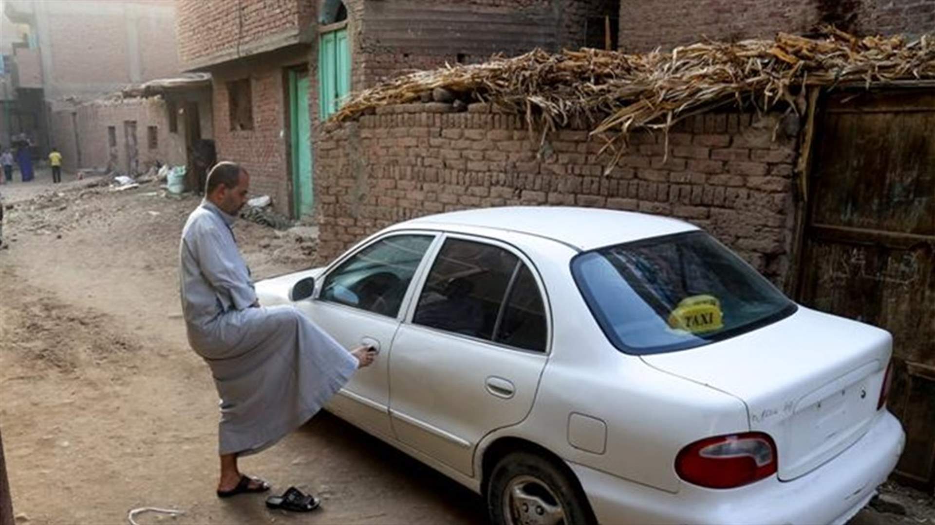 بالصور- مصري فقد يديه يقود سيارته ويعمل مستخدمًا قدميه