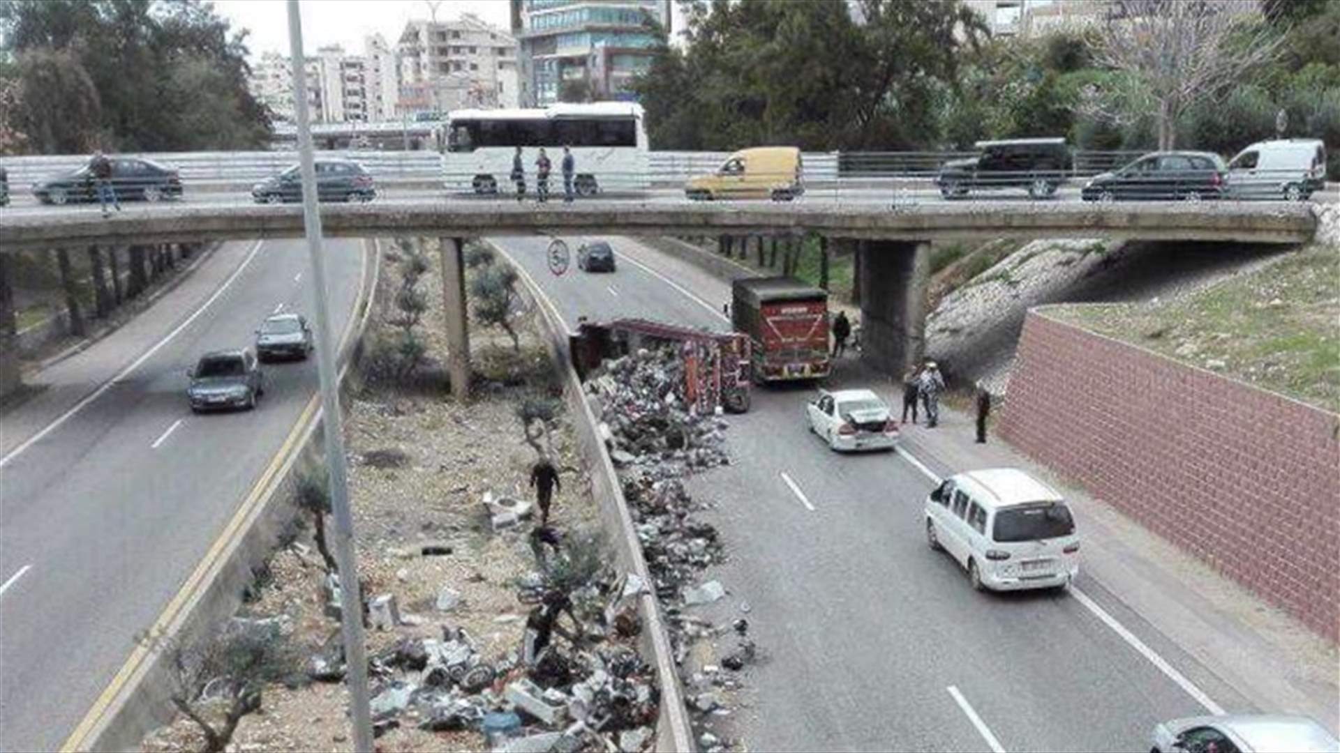 بالصور - انقلاب "بيك آب" على اوتوستراد جبيل عمشيت... وتناثر حمولته