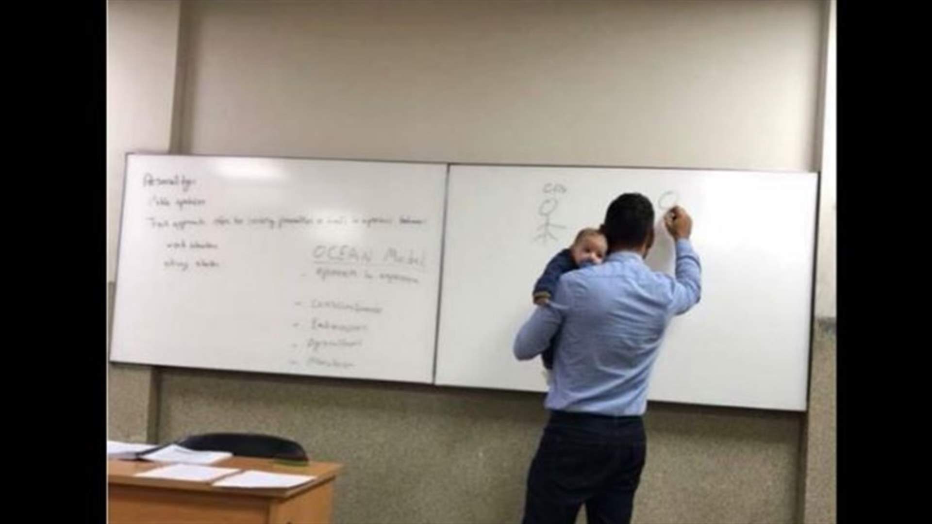 بالصور- في مشهد مفعم بالحنان...طفل يغفو على كتف استاذ في جامعة لبنانية خلال الشرح