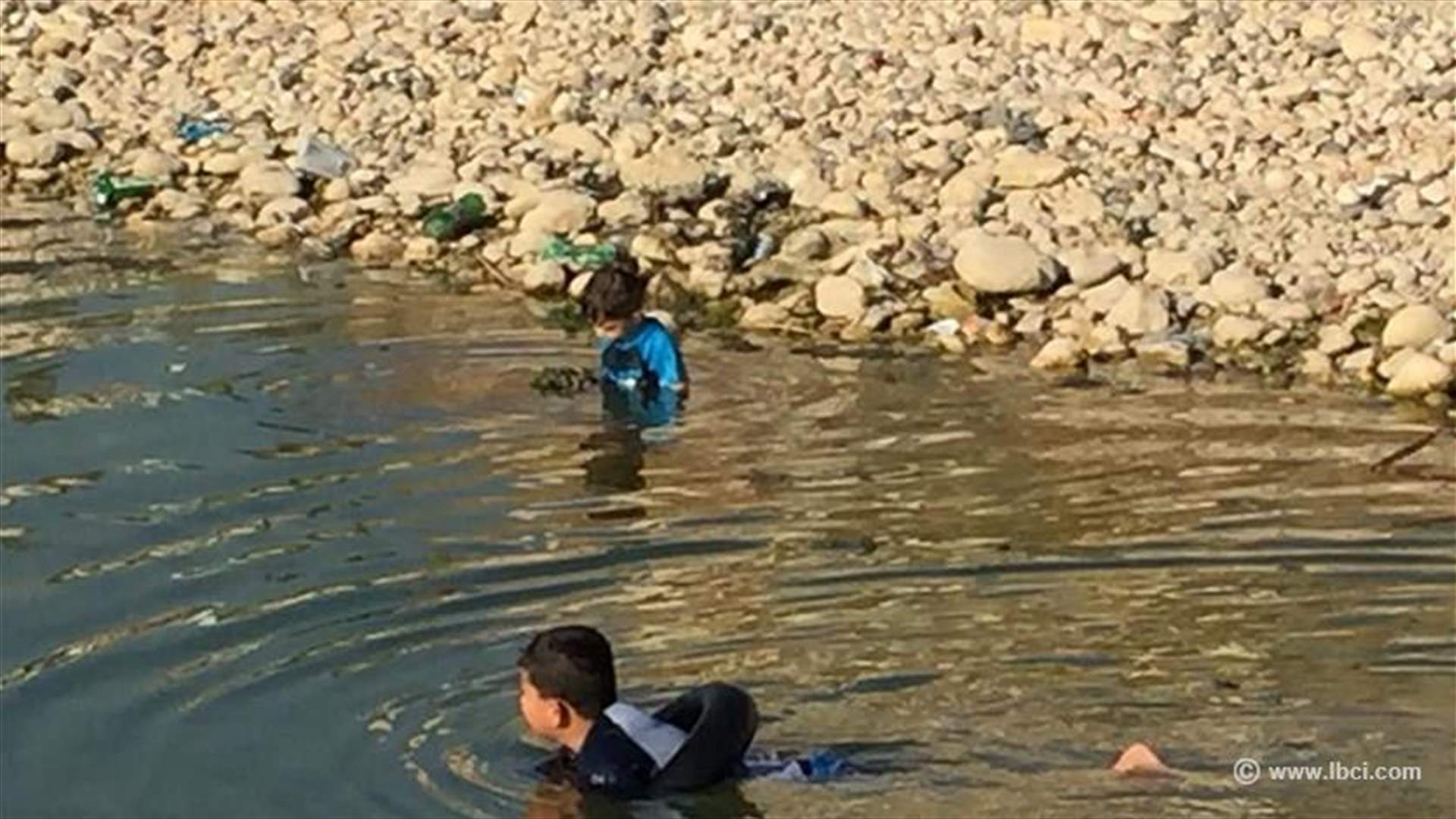 طفلان يسبحان في مستنقع مياه ملوث بالاوبئة والسموم... تحت أنظار الاهل!! (صور)