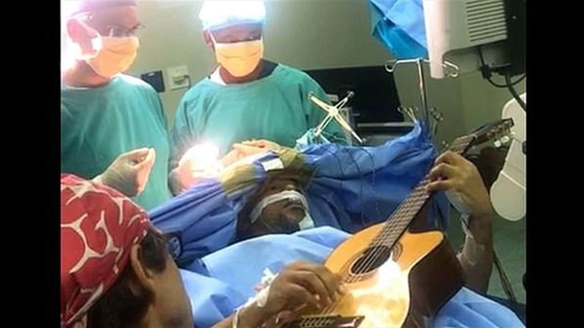 فنان يعزف على الغيتار أثناء خضوعه لعملية جراحية في الرأس (فيديو)