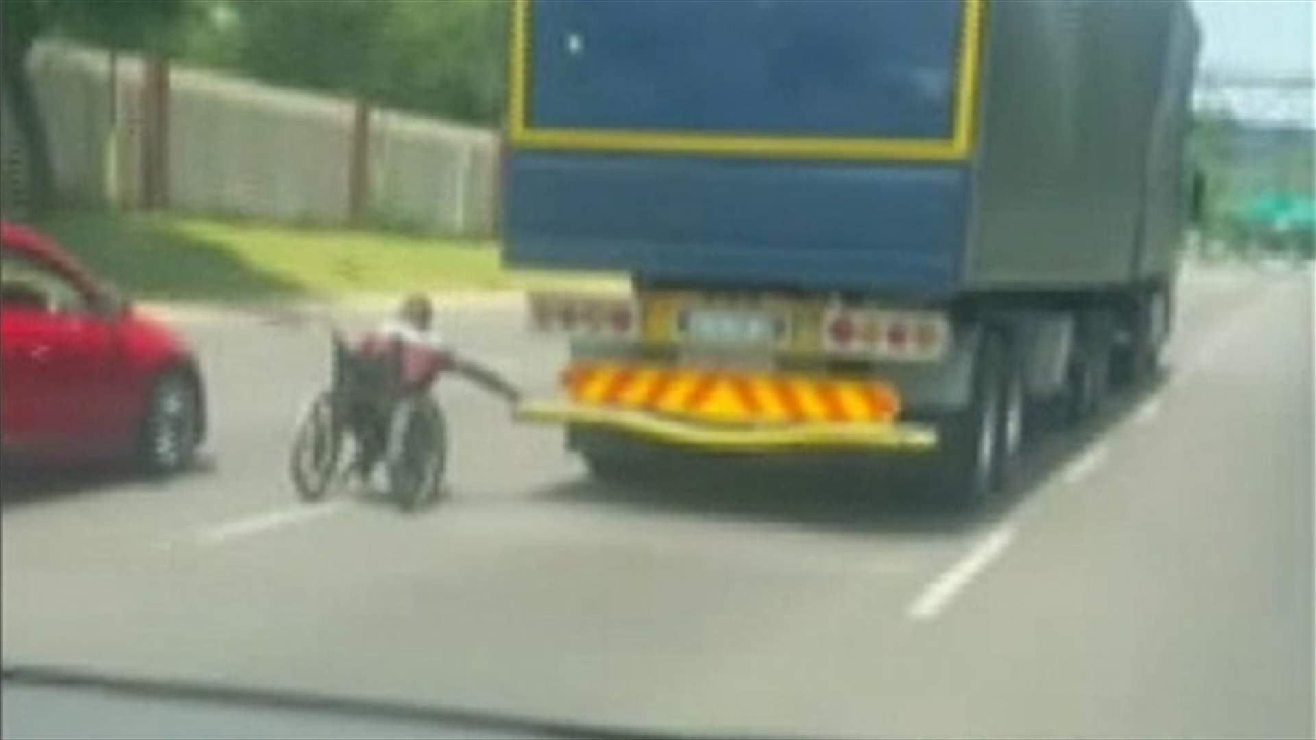 رجل على كرسي متحرّك صدم السائقين... أمسك بشاحنة تسير على طريق سريع (فيديو)