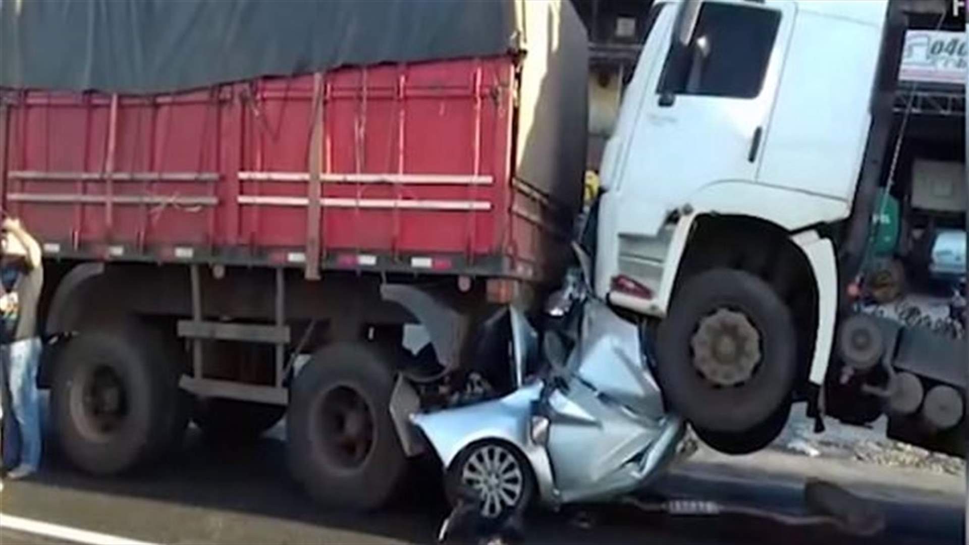 نجا من الموت بعدما سُحقت سيارته بين شاحنتين... فيديو صادم!