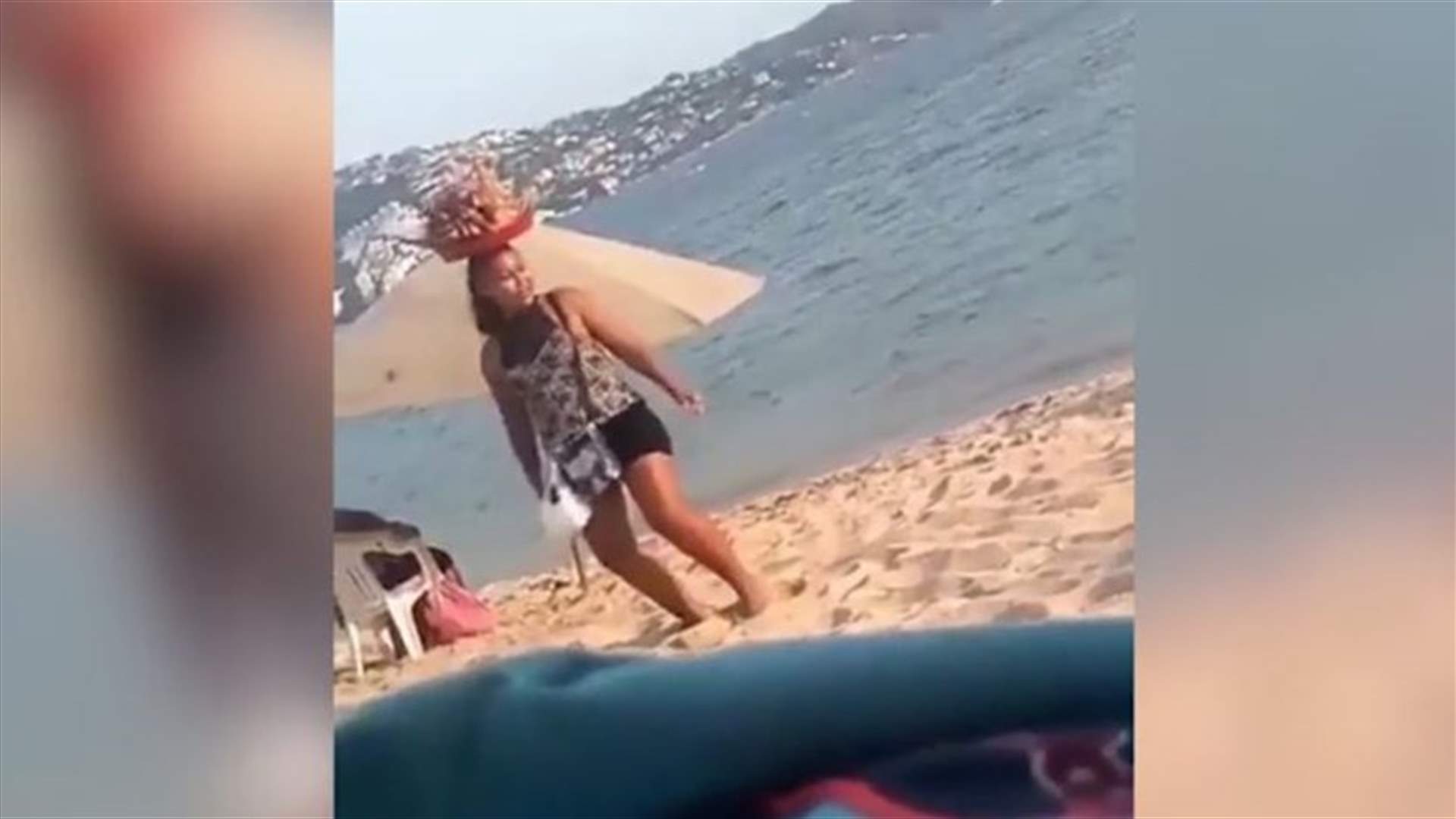 سيدة من الباعة المتجولين ترقص التويرك على الشاطئ لبيع وجبات الطعام (فيديو)