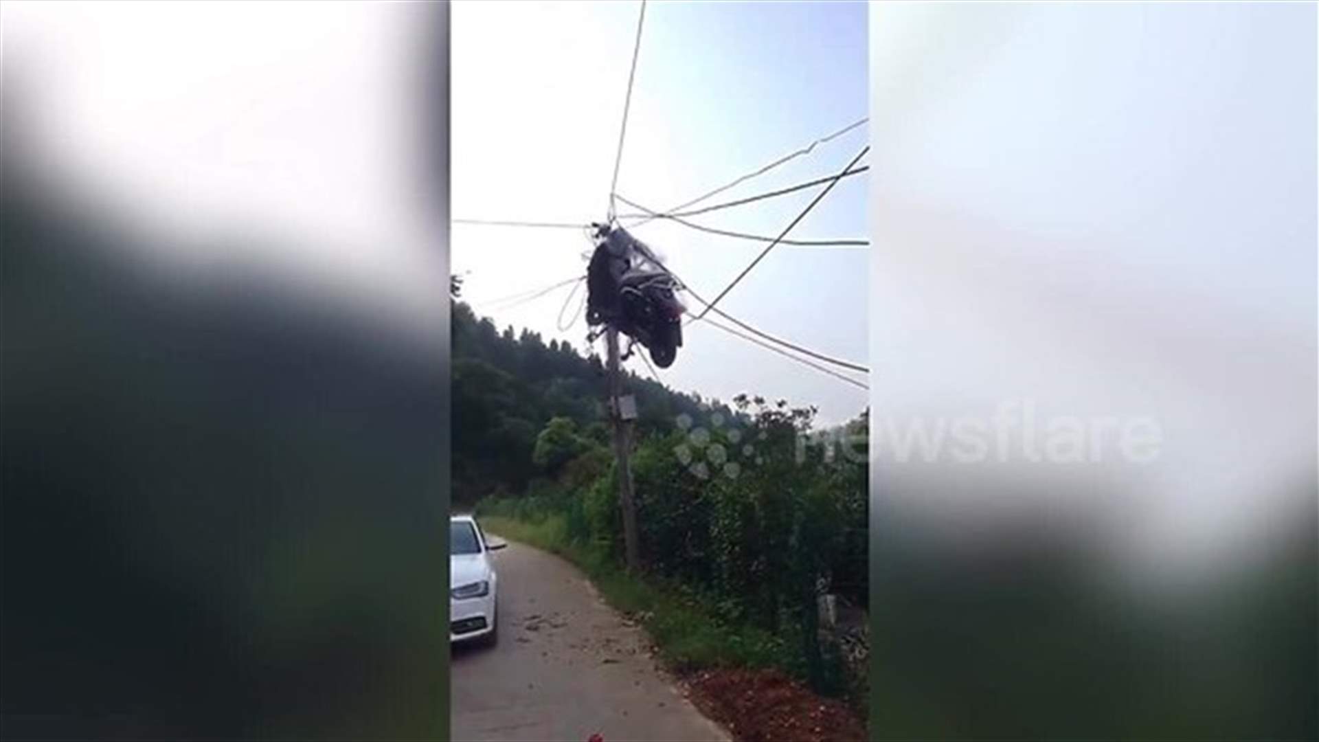 دراجة نارية عالقة بين خطوط الكهرباء في الجو... ما قصتها؟