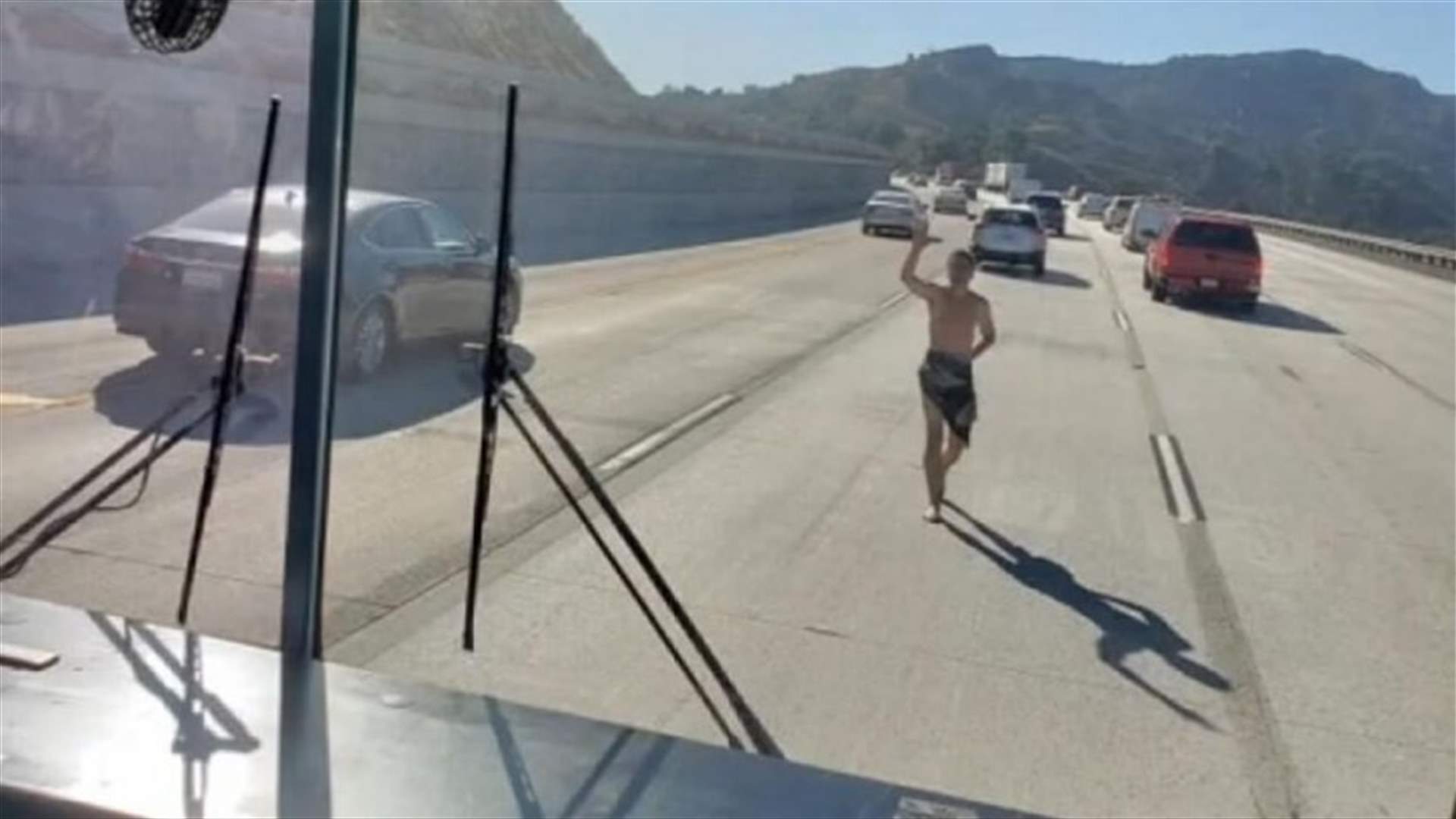 رجل شبه عارٍ يركض خلف حافلة مدرسة على الطريق السريع! (فيديو)
