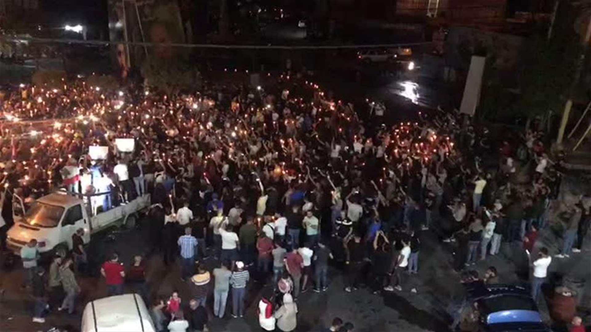 المتظاهرون عند دوار كفررمان أضاؤوا فجرًا الشموع لروح الشهداء (فيديو)