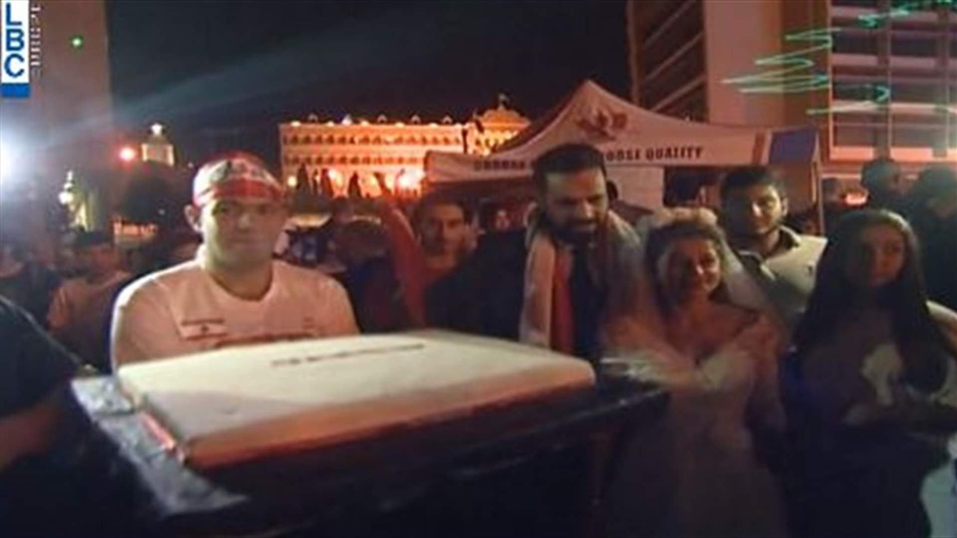 المشهد من وسط بيروت في الليلة السابعة... عروسان يقطعان قالب الحلوى (فيديو)