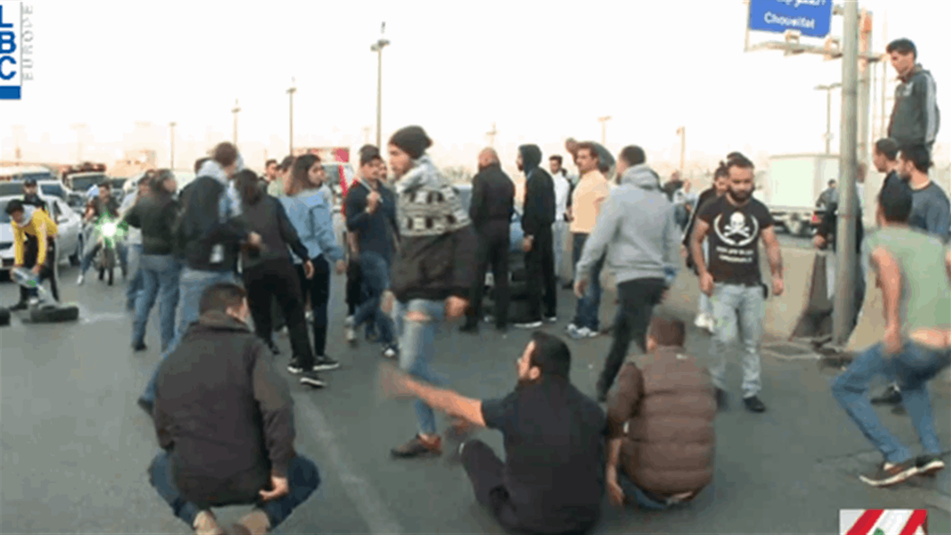المتظاهرون يفترشون الارض ويحرقون الاطارات على طريق المطار ...والمواطنون عالقون بسياراتهم (فيديو)