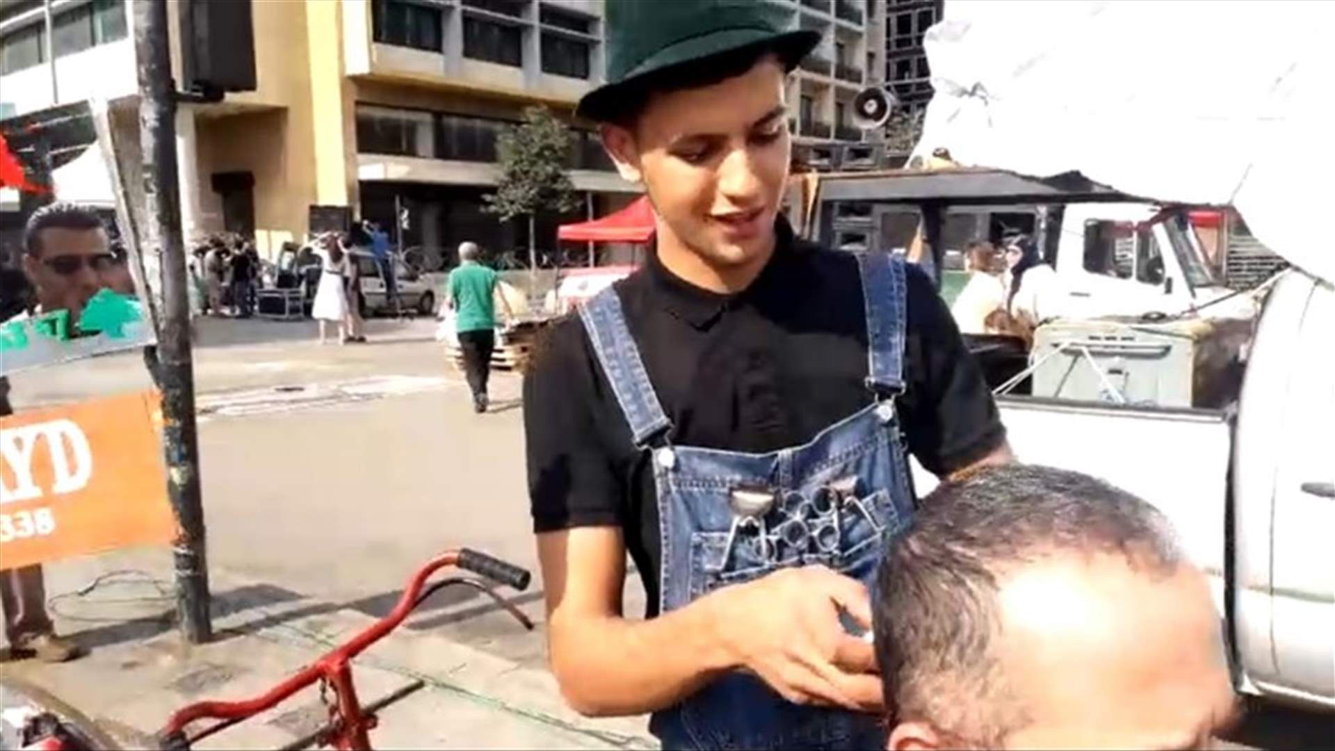 "حلاق الثورة" في ساحة رياض الصلح... وقصات شعر مجانية للمتظاهرين (فيديو)