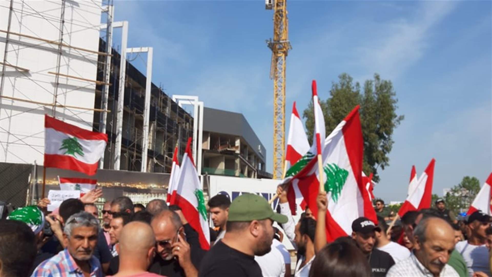 تجمع عند مدخل المطار للمطالبة باسترجاع الأموال المنهوبة