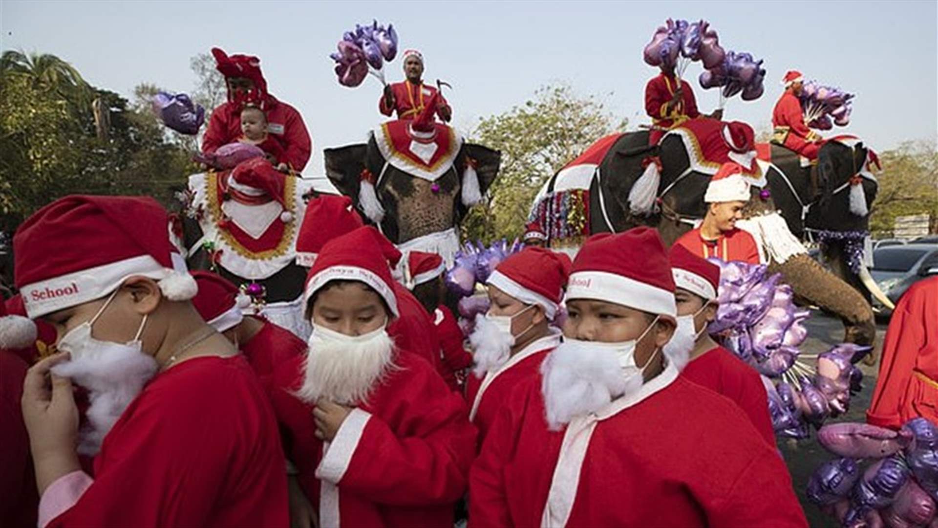 بمناسبة عيد الميلاد... الأفيال بزي بابا نويل توزع الهدايا في مدرسة بتايلاند (صور)