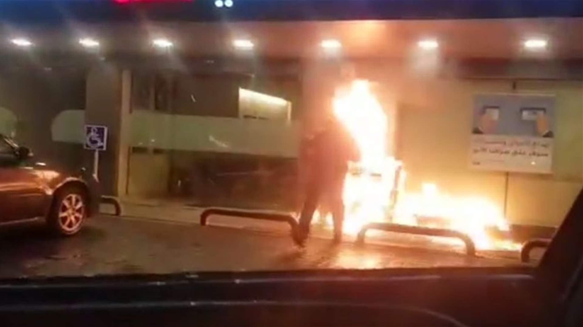 شابان يضرمان النار بـATM أحد المصارف (فيديو)
