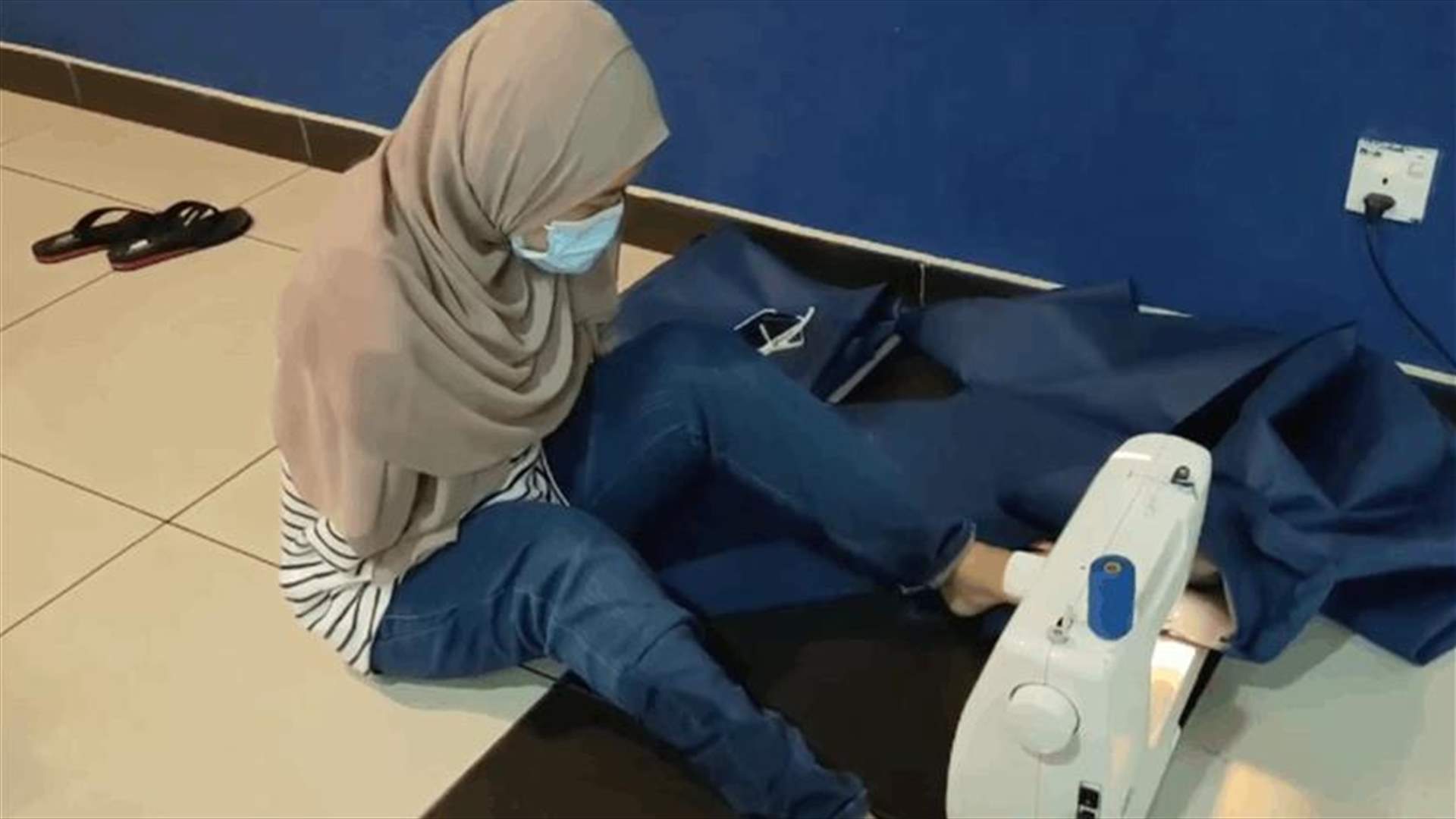 شابة ماليزية مبتورة اليدين تخيّط معدات الوقاية الشخصية من كورونا برجليها (فيديو)