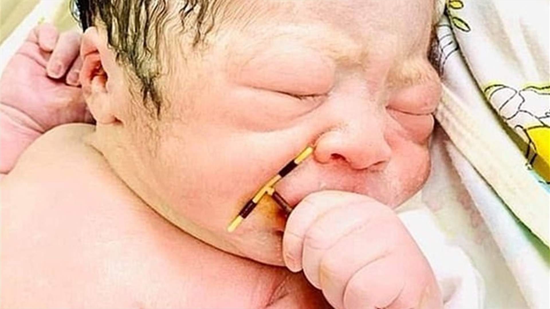 صورة طريفة لطفل حديث الولادة يحمل اللولب الرحمي الخاص بوالدته بين يديه (صور)