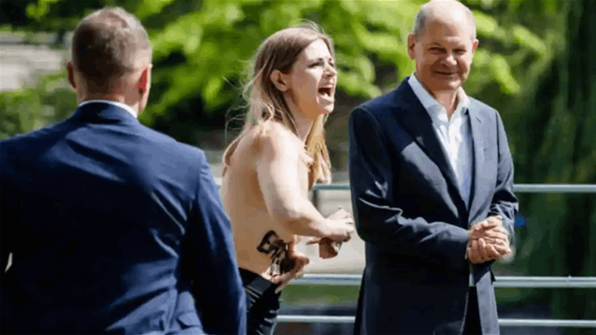 فتاتان تحتجان بصدور عارية أمام المستشار الألماني... ما السبب؟ (فيديو)