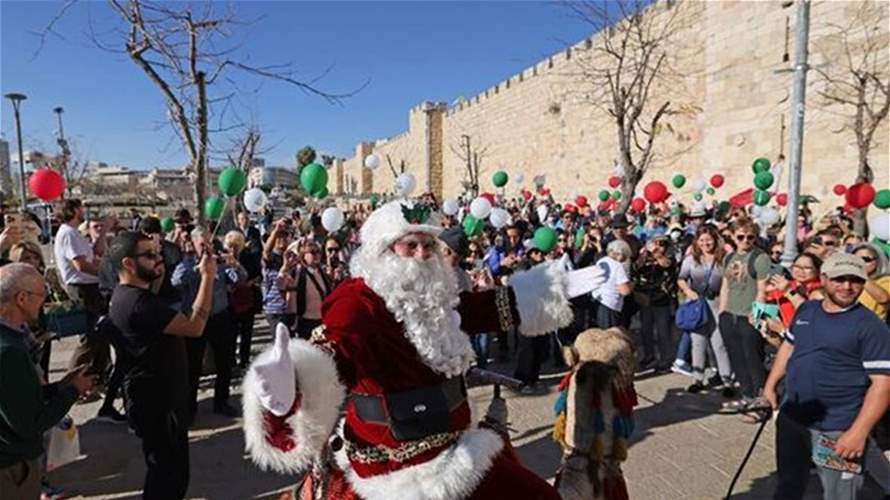 في القدس الشرقية... "بابا نويل" فلسطيني يضفي الفرح على الحجّاج المسيحيّين وغيرهم (صور)