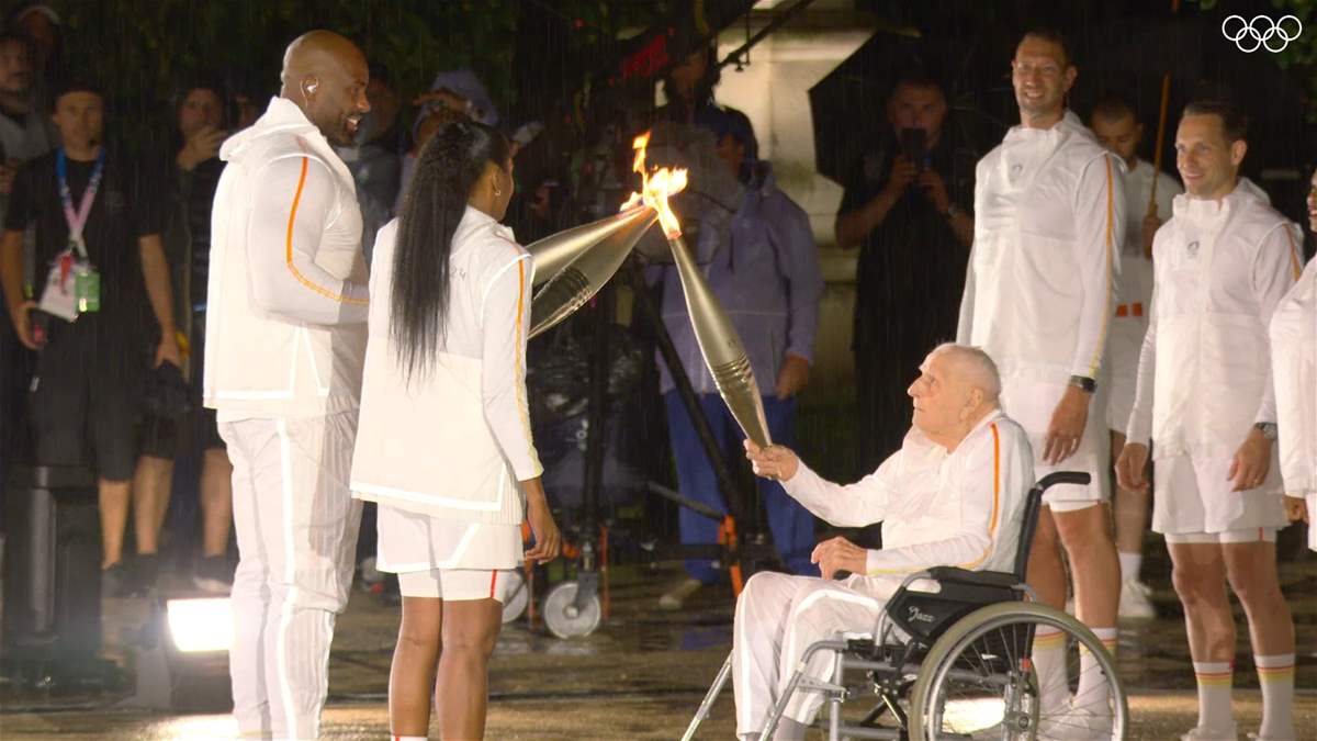 الفرنسية ماري-جوزيه بيريك الحائزة على ثلاث ذهبيات أولمبية وتيدي رينير يشعلان المرجل الأولمبي